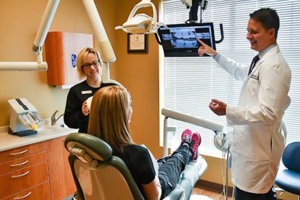 Dentist reviewing digital X-rays as part of top dental services.