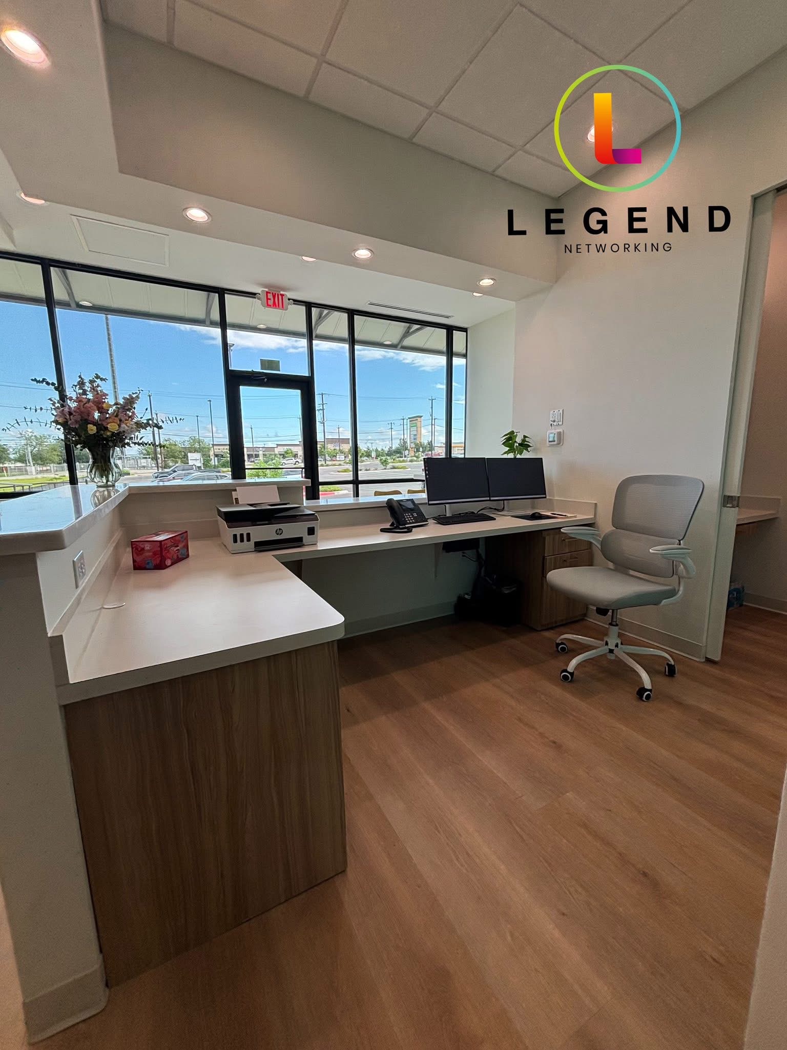 Ray Orthodontics front workstation with dual monitors, phone and printer near the reception windows.