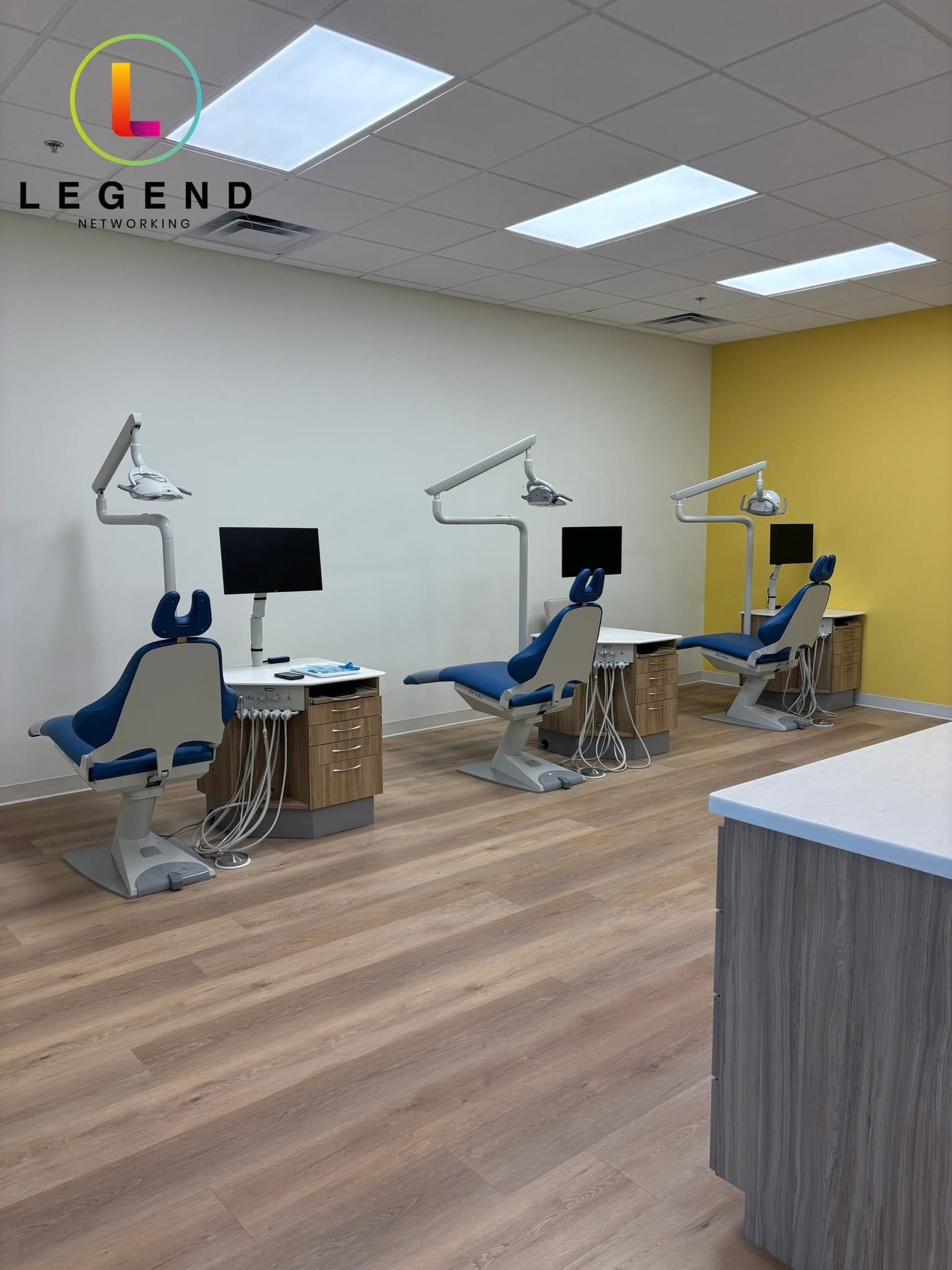 Ray Orthodontics treatment room with three patient chairs and chairside monitors.